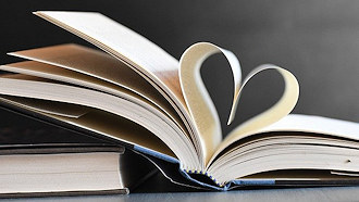 open book with pages bent in the shape of a heart
